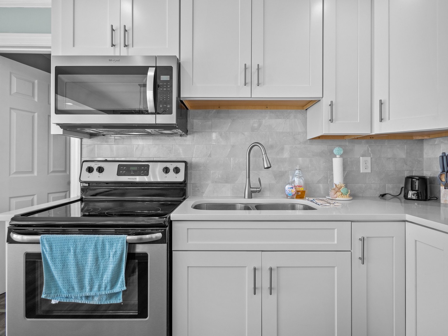 Your modern kitchen awaits with sleek white cabinets, stainless steel appliances, and everything you need to create memorable meals during your stay.
