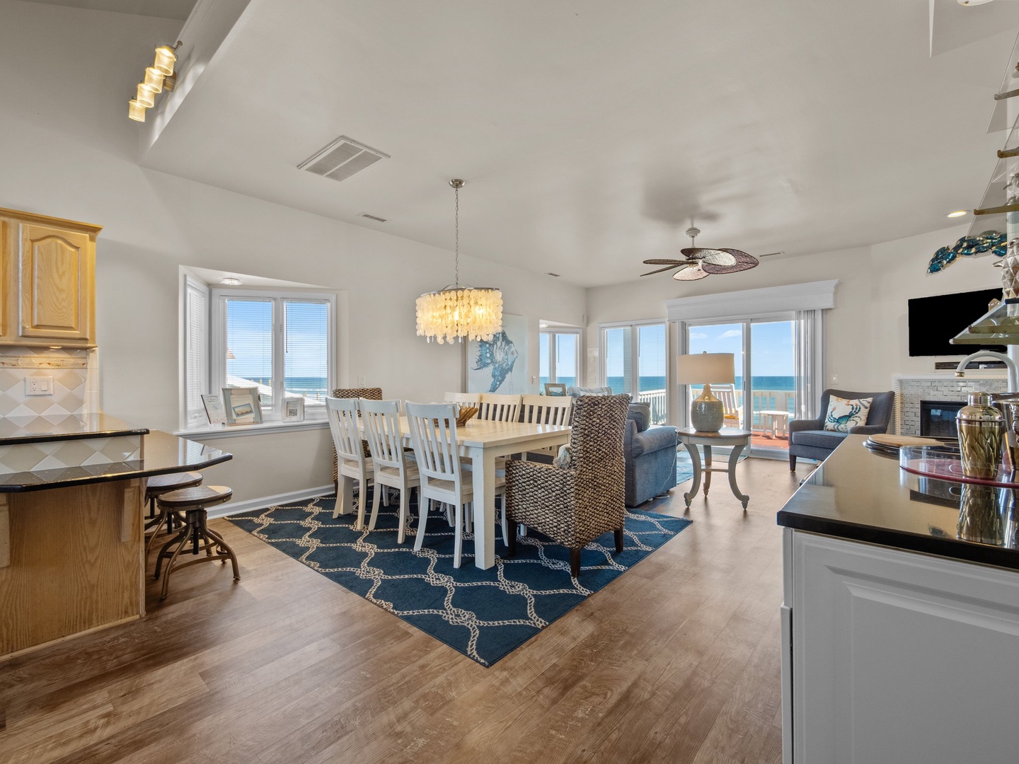 Relax in your bright open-concept living space where coastal elegance meets comfort, featuring stunning ocean views through expansive windows.