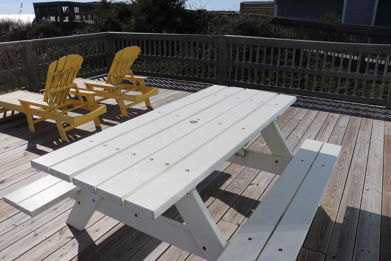Your spacious deck awaits with sunny yellow Adirondack chairs and a picnic table for seaside meals.