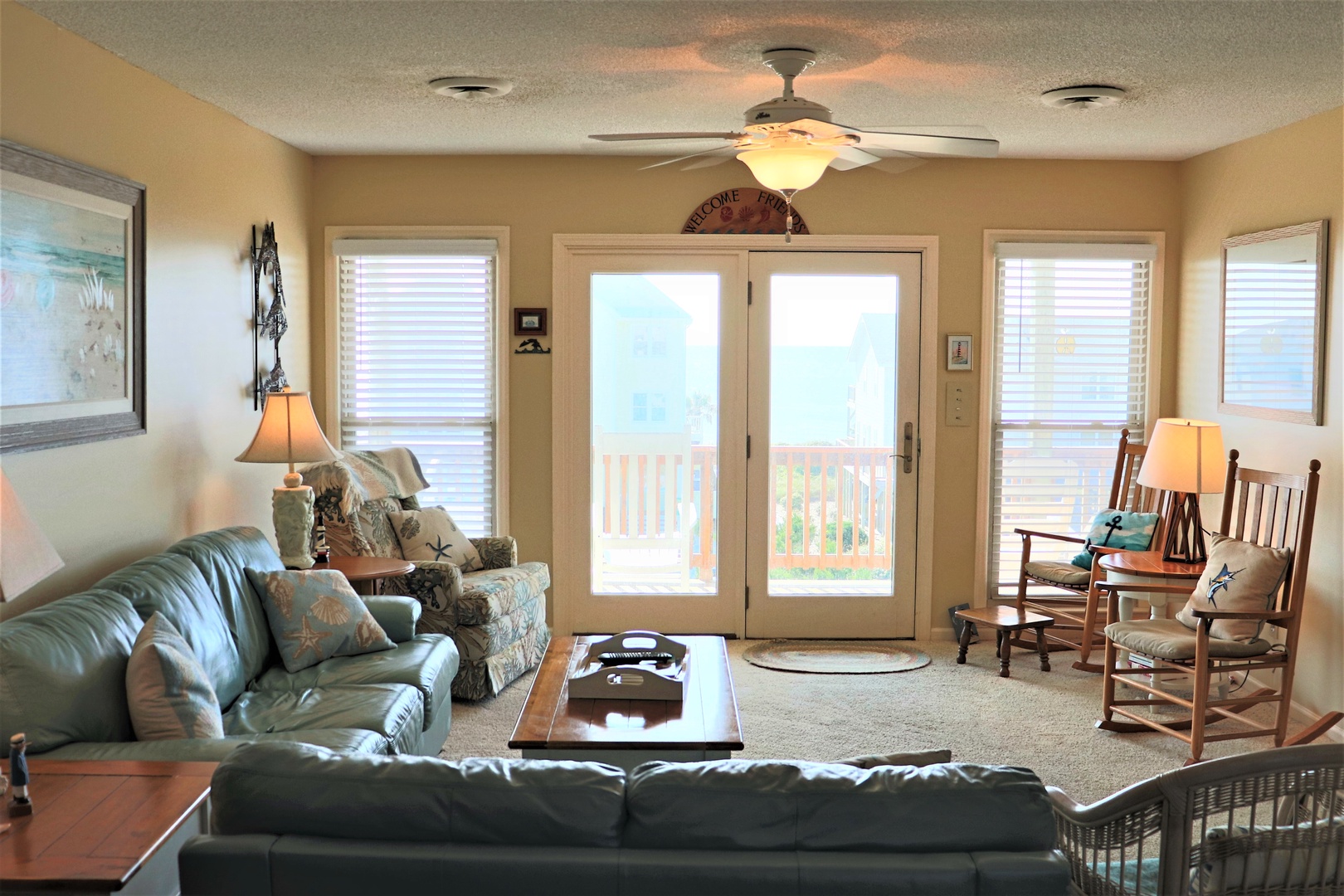 Relax in your cozy living room with comfortable leather seating and gentle ceiling fan breezes while natural light streams through French doors.