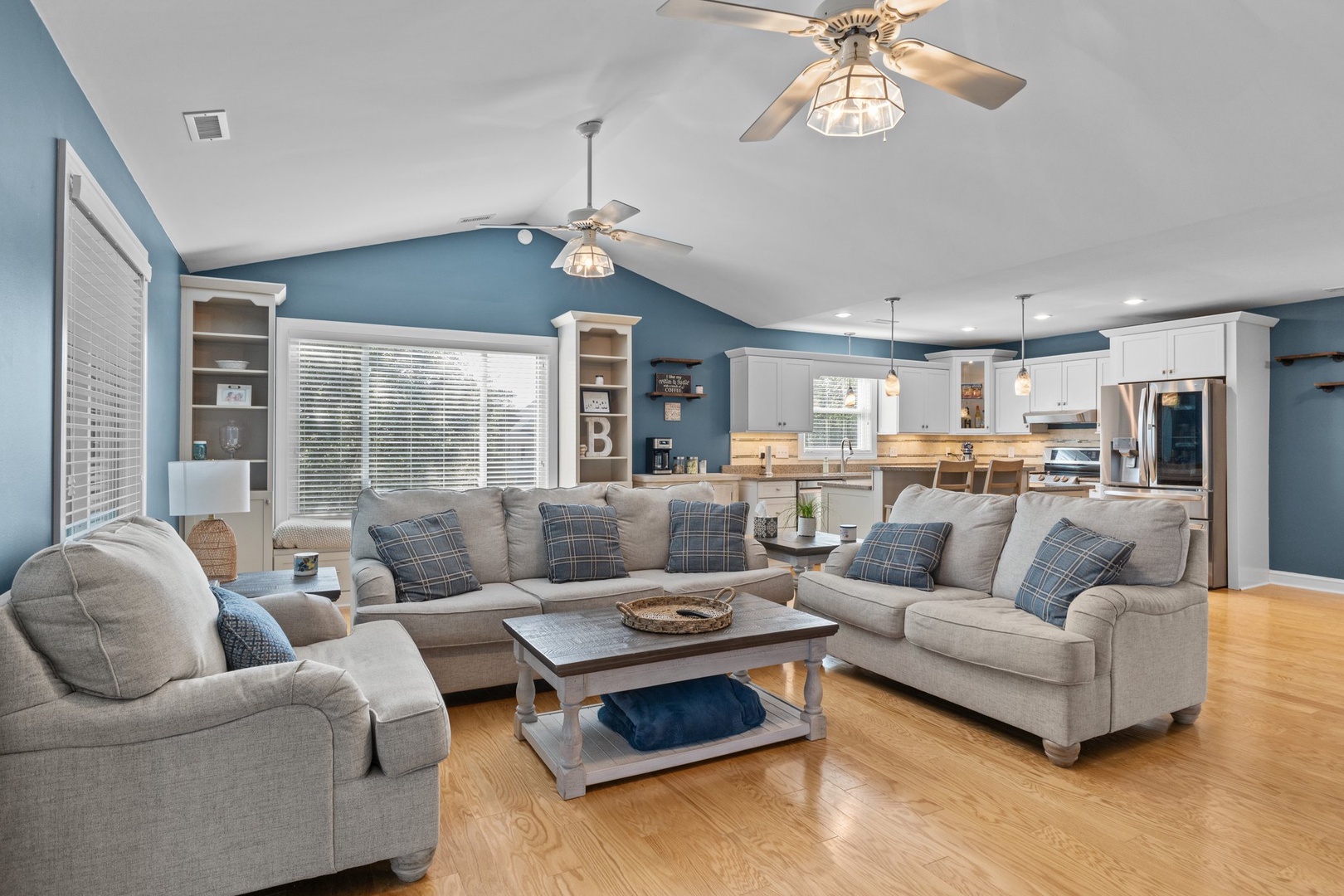 Relax in your spacious living room with cozy sectional seating, ceiling fans, and an open kitchen perfect for entertaining.