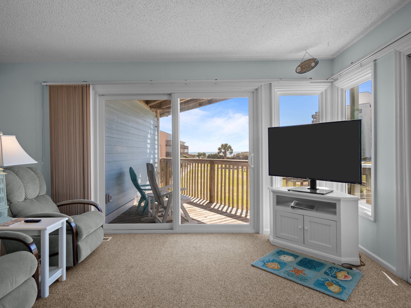 Relax in your bright coastal living room where ocean breezes flow through sliding doors to your private balcony.