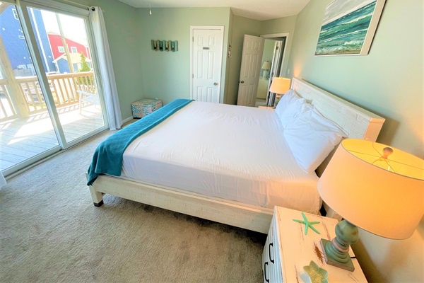 Wake up to sunlight streaming through your private balcony doors in this serene bedroom with ocean-inspired décor and crisp linens.