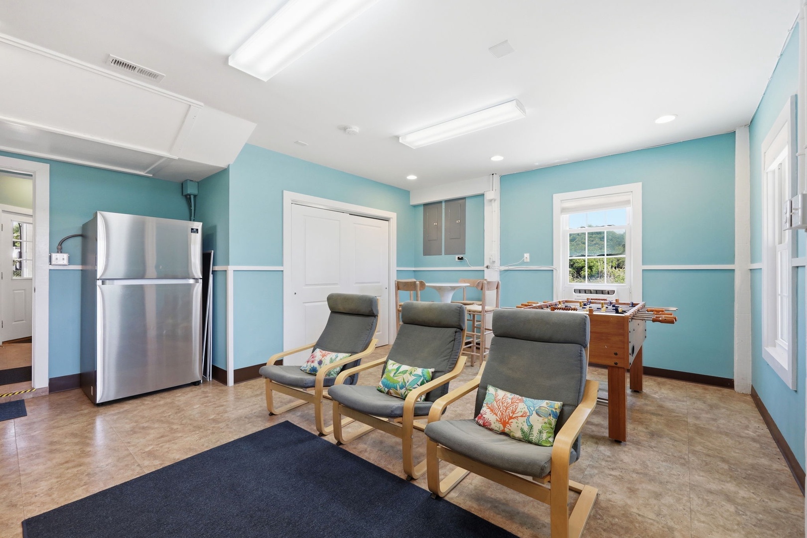 Bright communal lounge with calming blue walls, comfy seating, foosball fun, and everything you need to relax with fellow travelers between adventures.