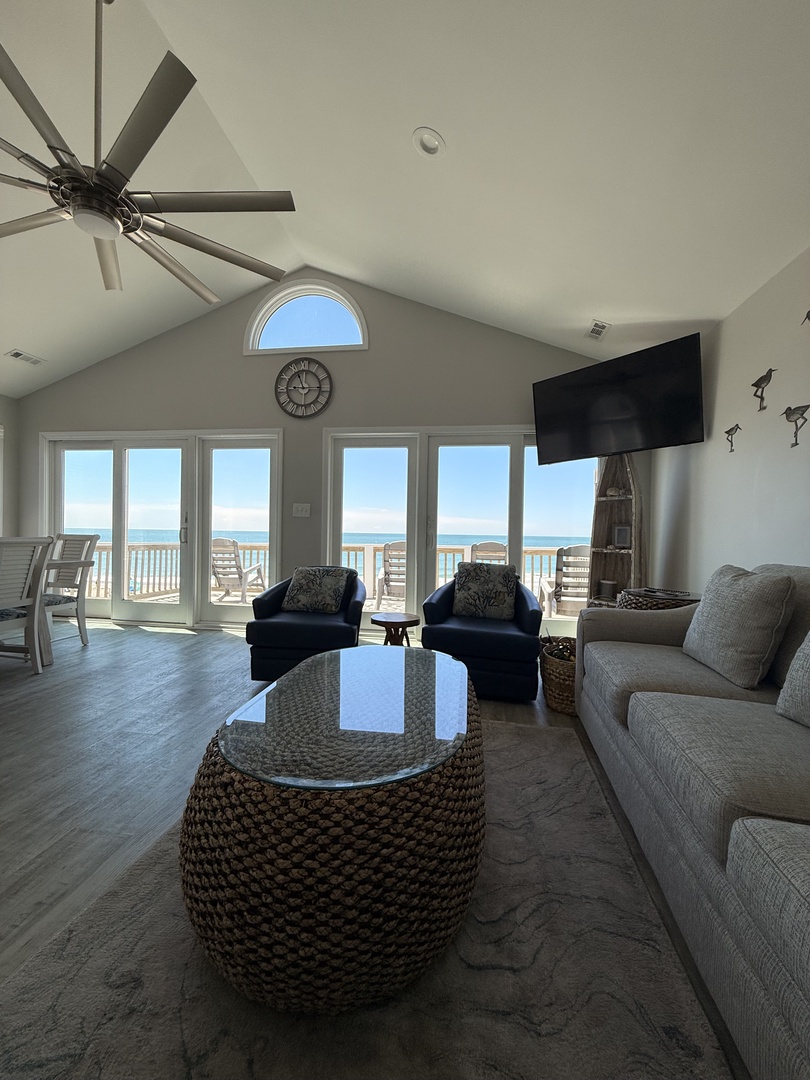 Relax in your stylish living space with plush seating and stunning coastal views through expansive windows. Modern décor and a private balcony await your getaway.