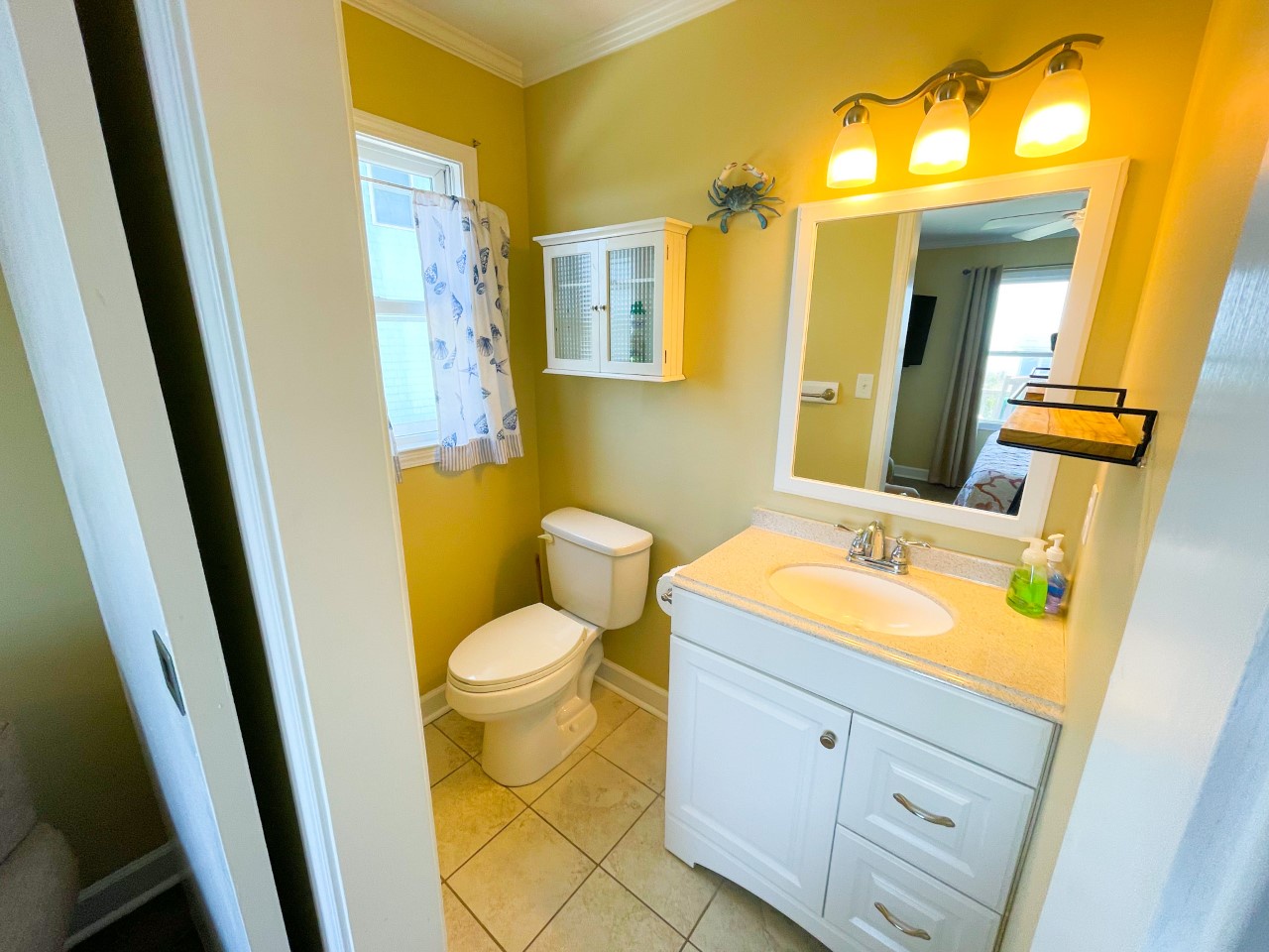 Step into your bright, coastal-themed bathroom where sunny yellow walls and cheerful décor create the perfect morning routine.
