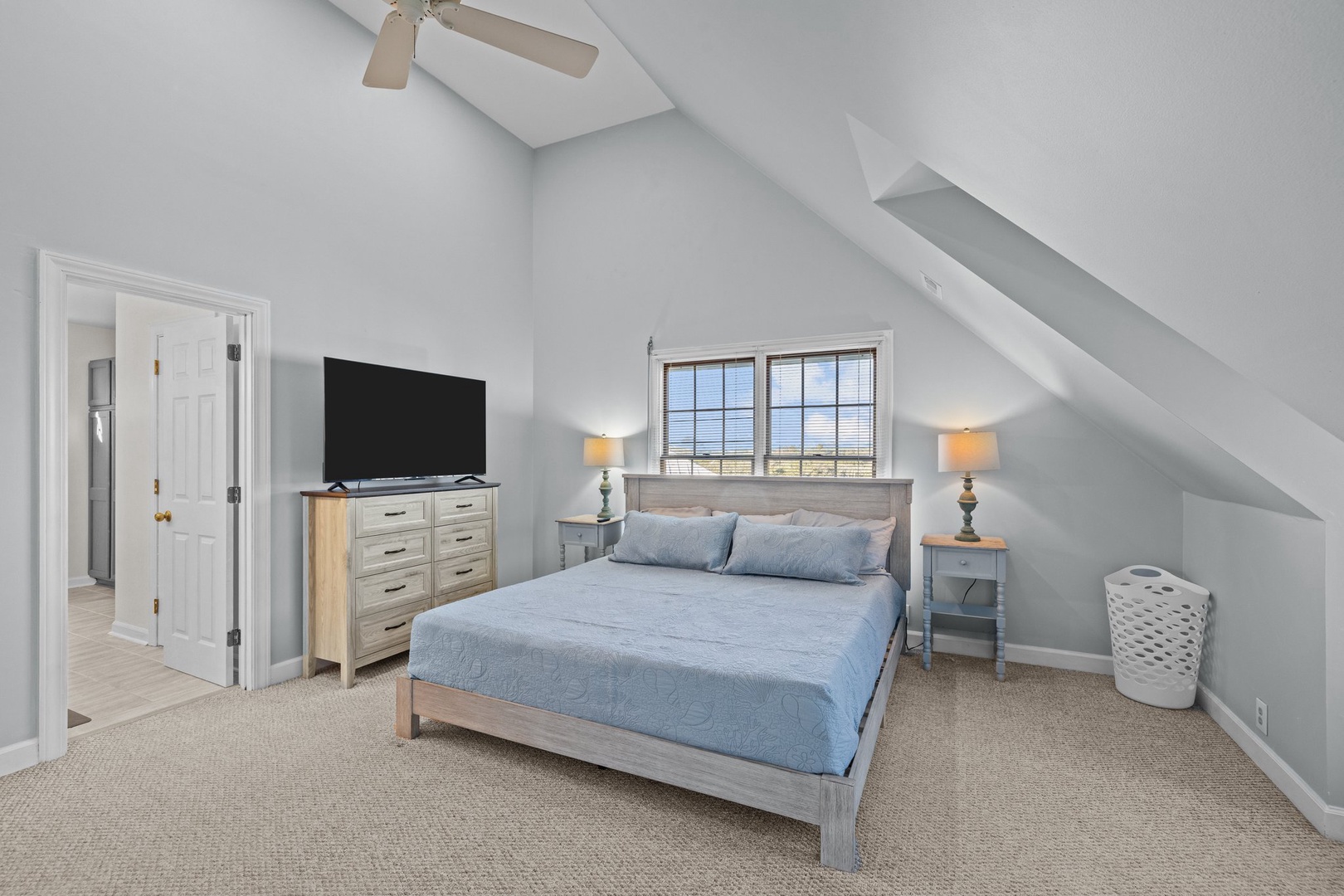Unwind in your peaceful bedroom retreat with soaring vaulted ceilings, cozy blue linens, and thoughtful touches that make relaxation effortless.