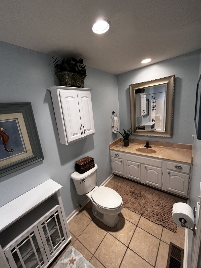 Your bright, well-appointed bathroom features modern fixtures, warm wood accents, and thoughtful touches like soft towels ready for your stay.