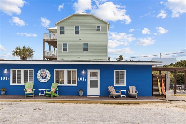 Charming blue beachside building with comfortable outdoor seating and coastal character in a peaceful neighborhood setting.