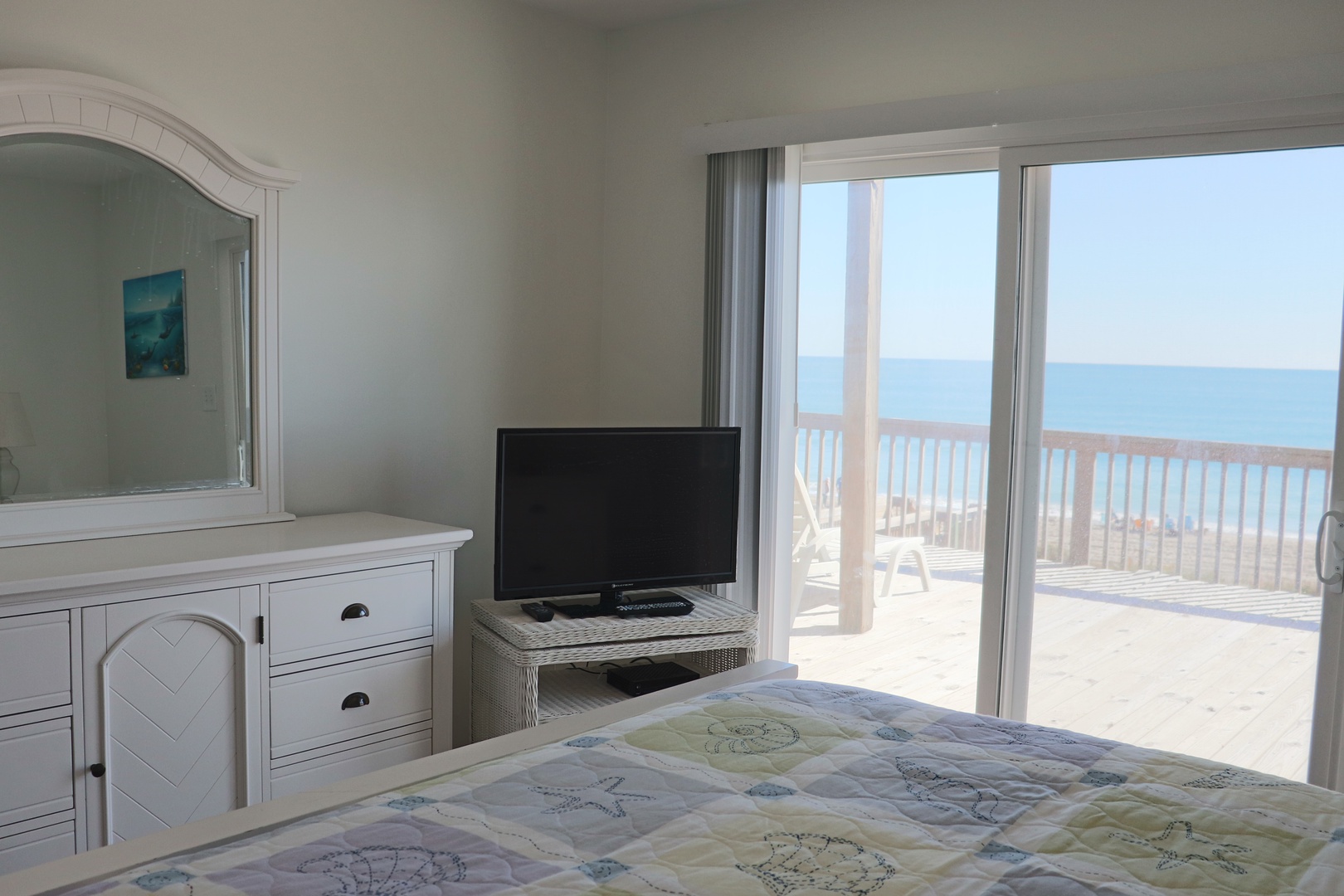 Wake up to endless ocean views from your beachfront bedroom, where morning light streams through sliding doors to your private deck.