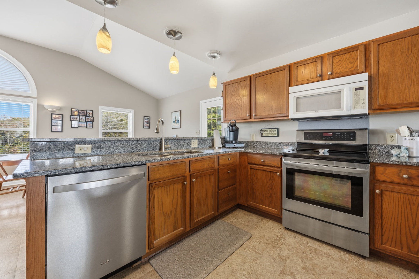Your fully equipped kitchen features granite counters, stainless appliances, and warm wood cabinetry - perfect for creating memorable meals during your stay.