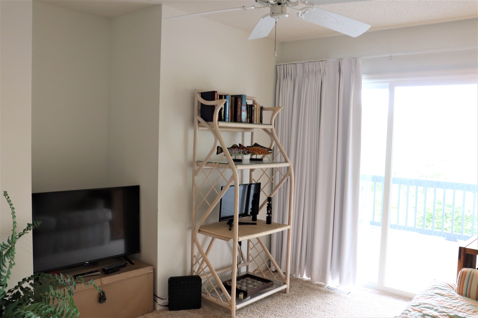 Your bright living space features a cozy reading nook with books, entertainment center, and balcony access for morning coffee moments.