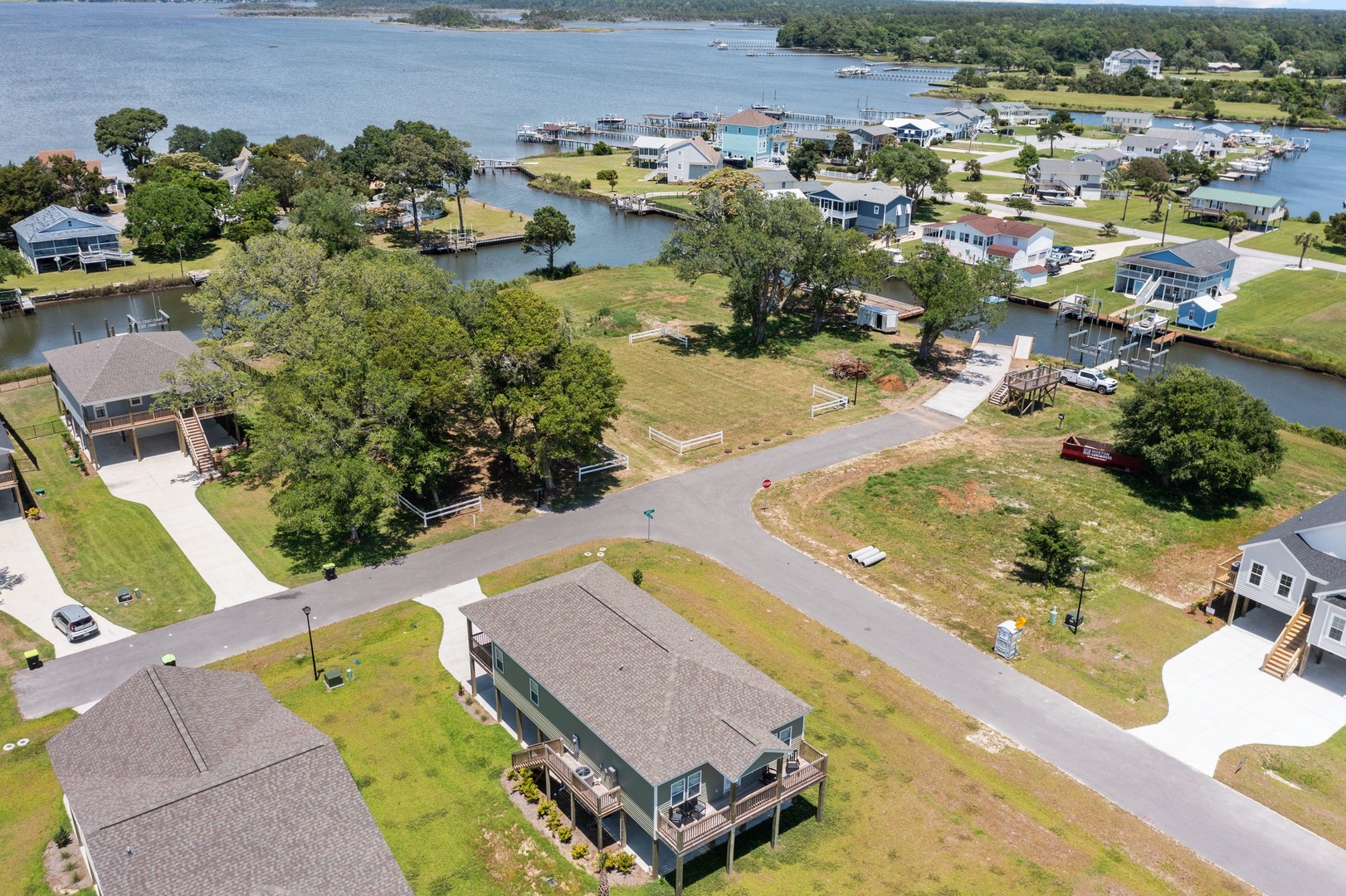 Aerial view of a peaceful waterfront community featuring vacation homes nestled along scenic lake shores with boat access and tree-lined streets.