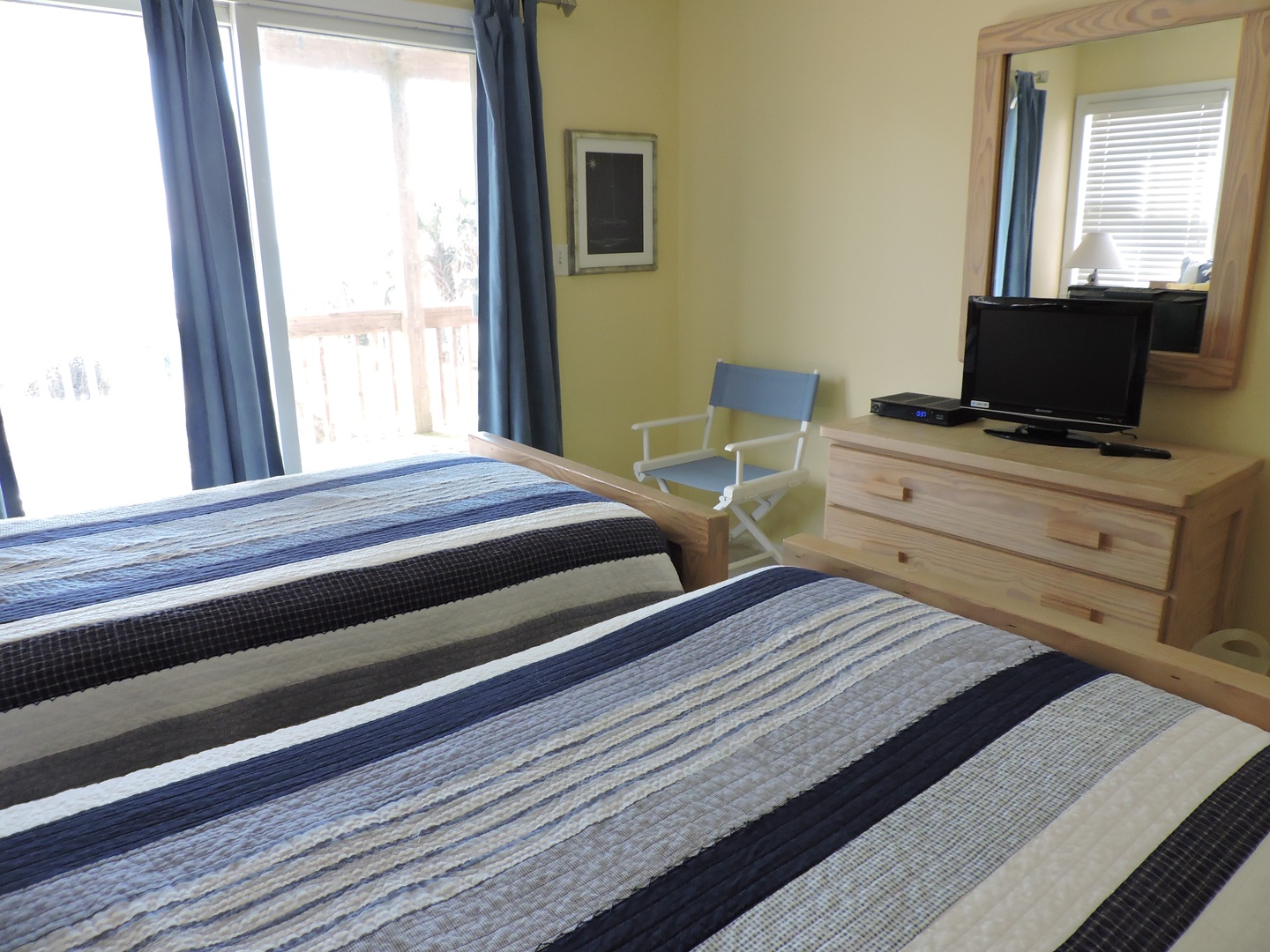 Settle into your comfortable bedroom with twin beds, TV entertainment, and bright natural light streaming through your private balcony doors.