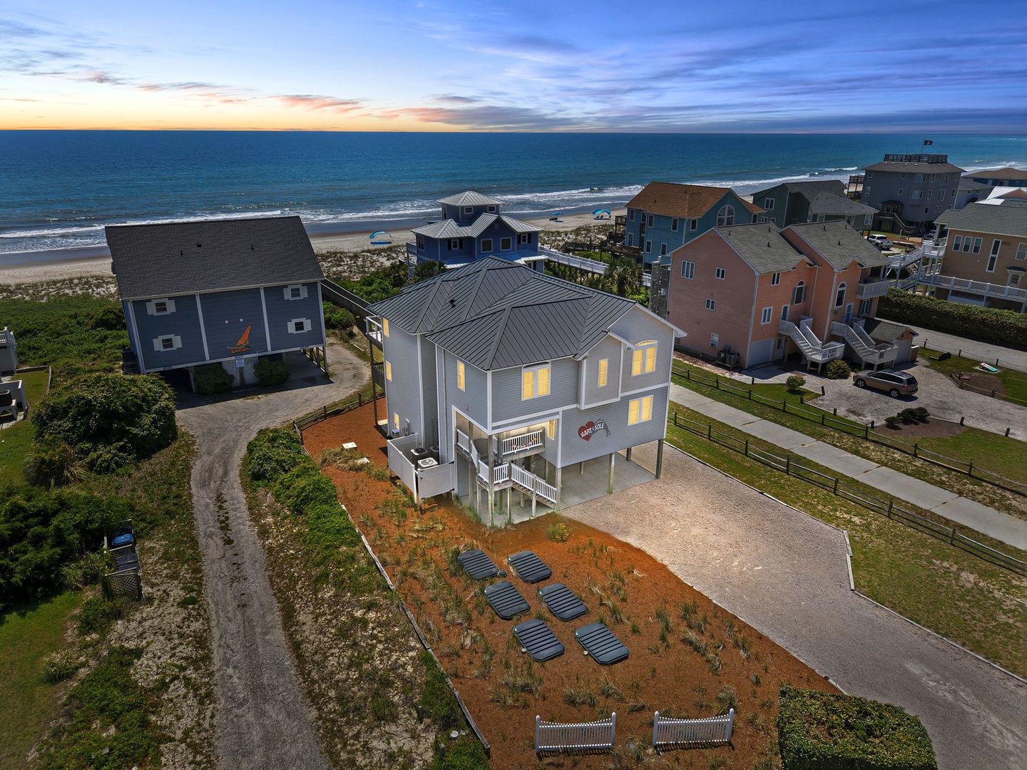 Beachfront vacation rental featuring direct beach access, coastal views, and spacious parking, located in a peaceful residential neighborhood along the shoreline.