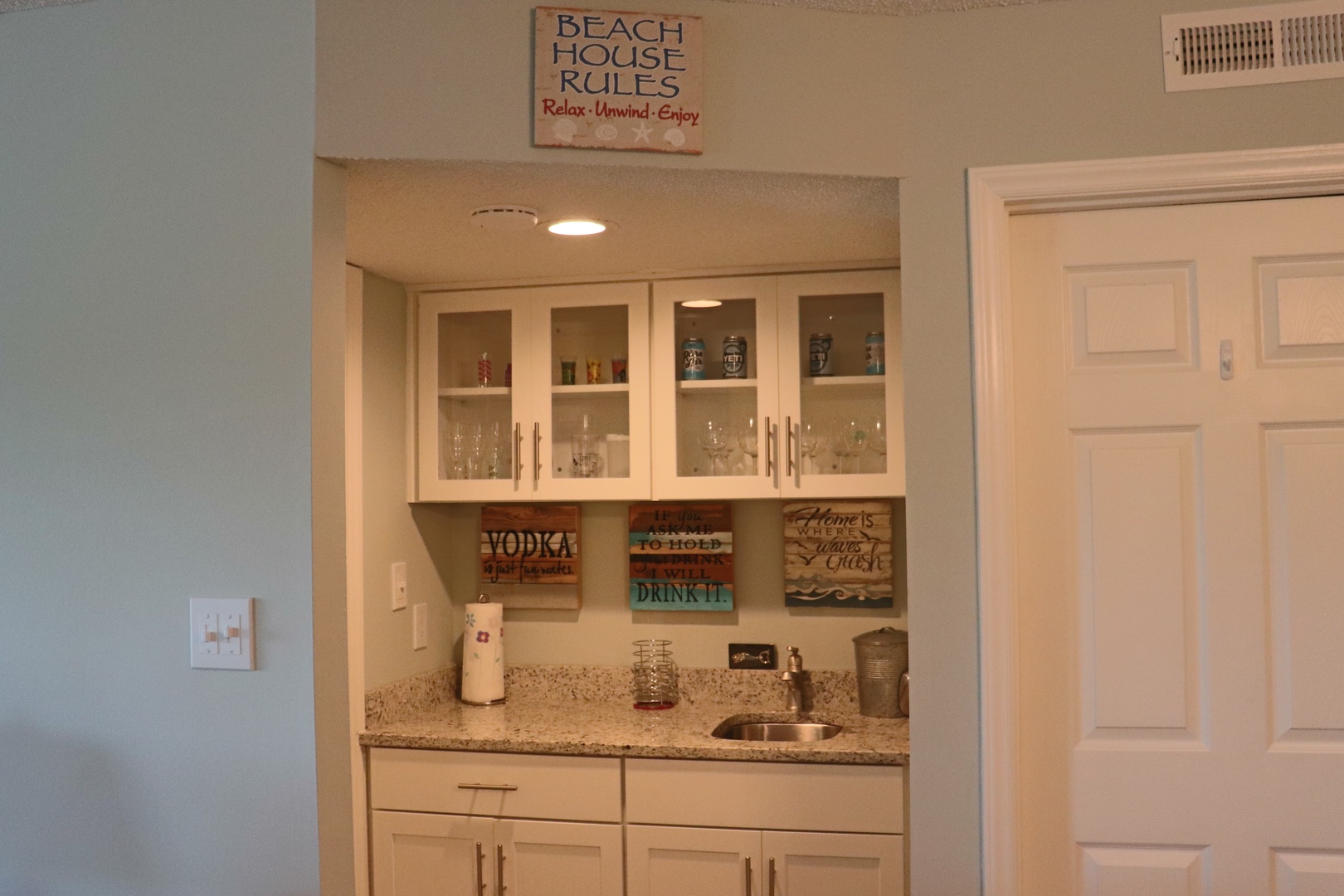 Your beach-themed wet bar awaits with granite counters, sink, and glassware storage—perfect for mixing sunset cocktails after sandy adventures.