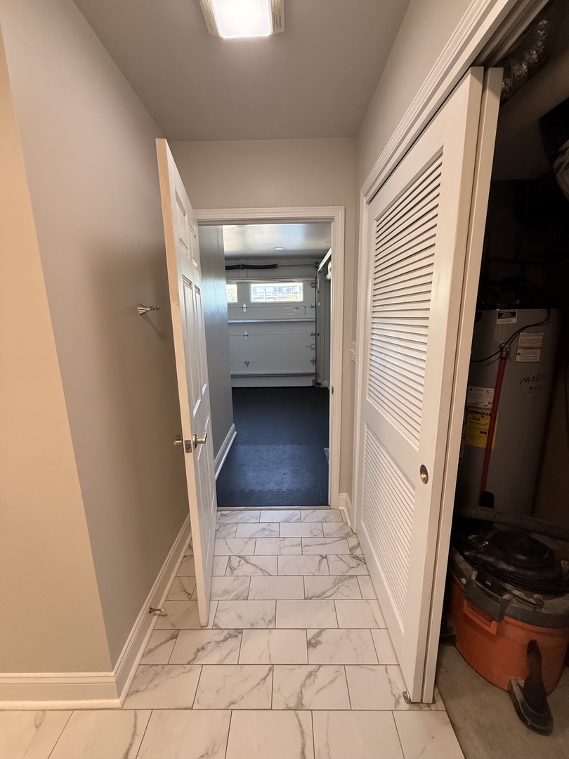 Modern bathroom features elegant marble-look tiles, a sleek vanity with dual sinks, and crisp white finishes that create a spa-like sanctuary for your stay.