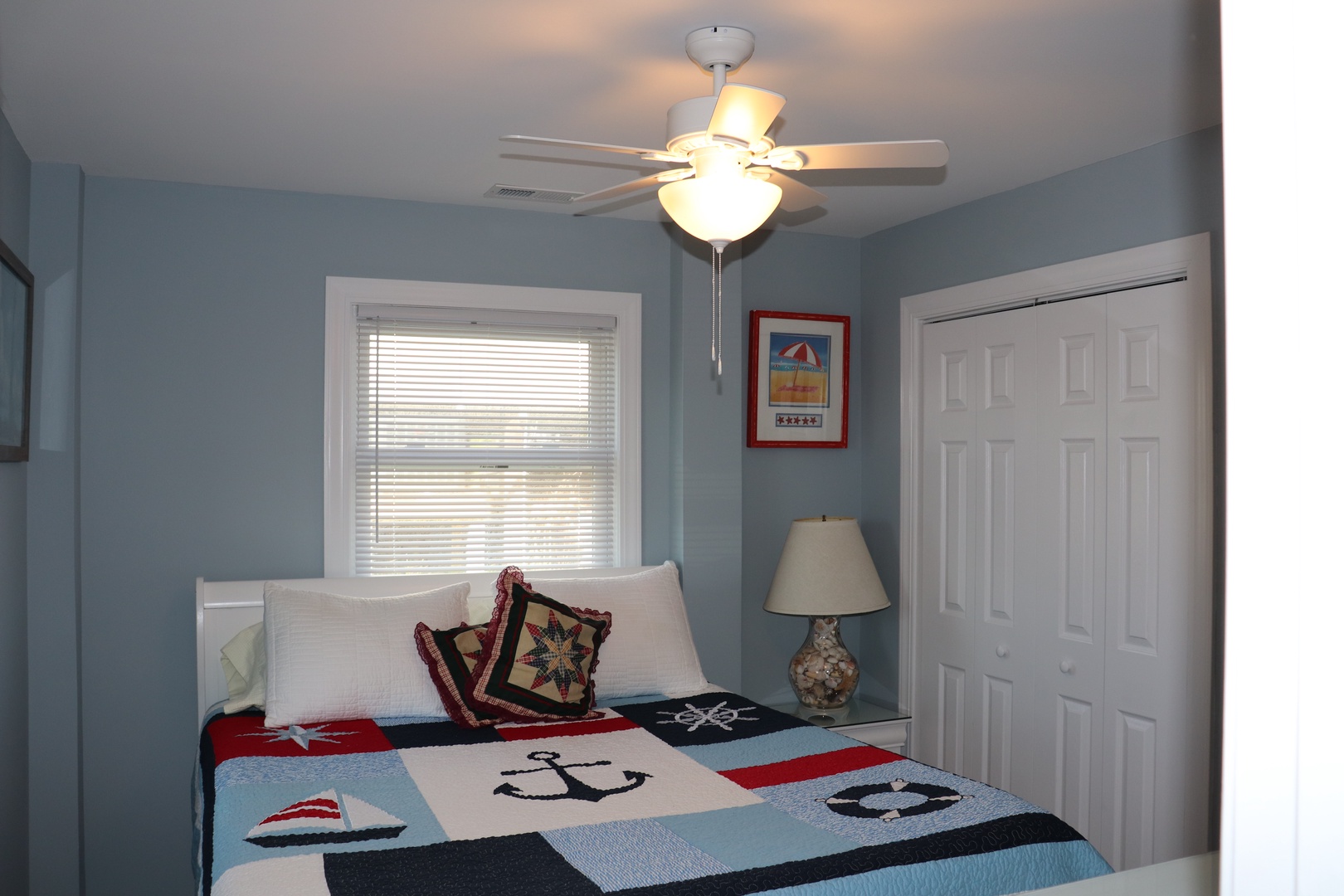 Drift off in your cozy nautical bedroom with charming quilt details and gentle ceiling fan breeze.