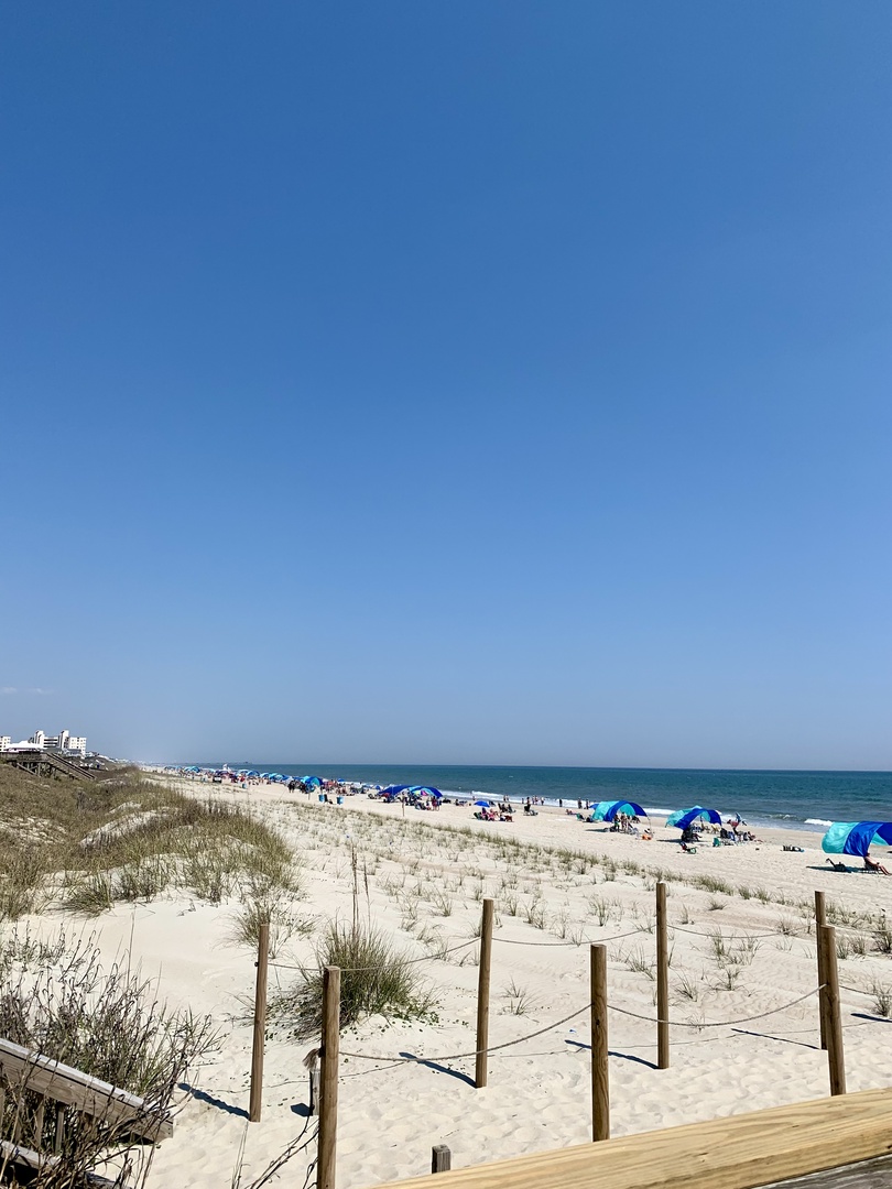 Pristine beach with white sand and turquoise waters stretches along the coastline, offering natural beauty near the property.