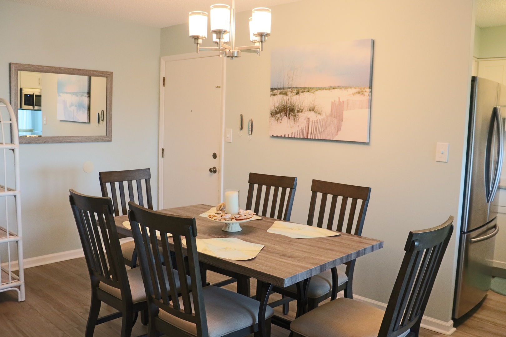 Gather around your elegant dining table for memorable meals, with beach artwork setting a coastal mood.