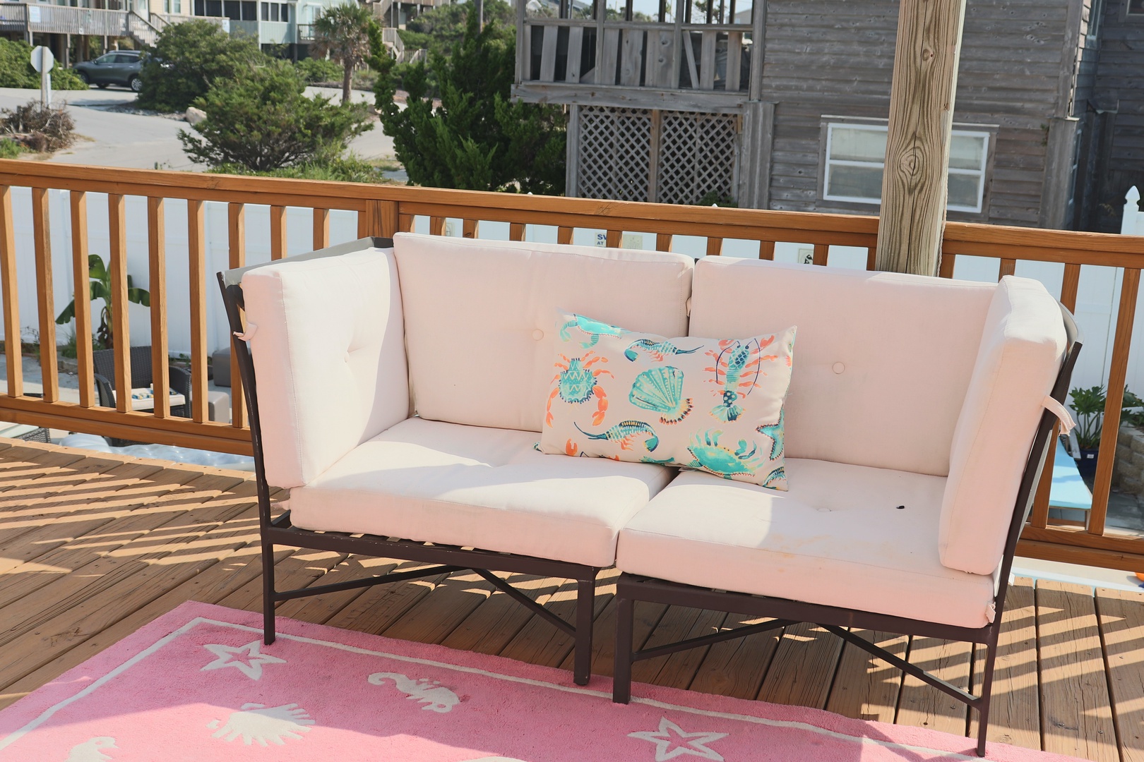 Settle into your private deck with plush seating and colorful coastal pillows, perfect for morning coffee or sunset relaxation.