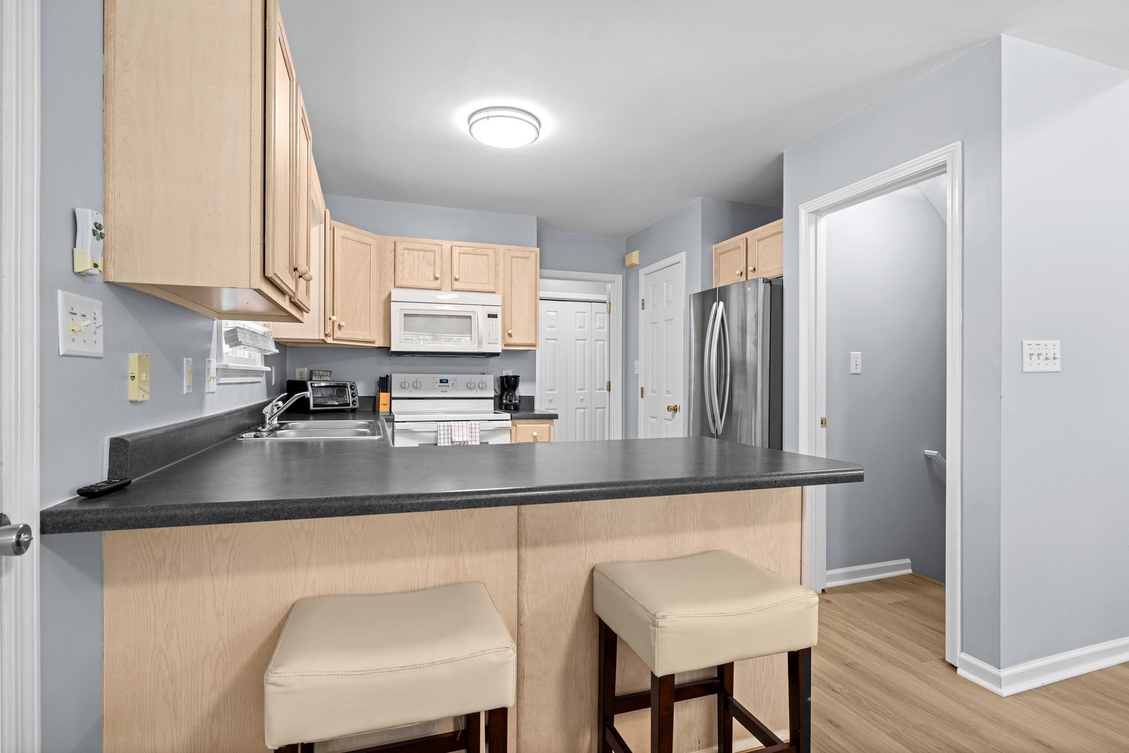 Your fully equipped kitchen features granite countertops, stainless steel appliances, and a convenient breakfast bar with comfortable seating for casual dining.