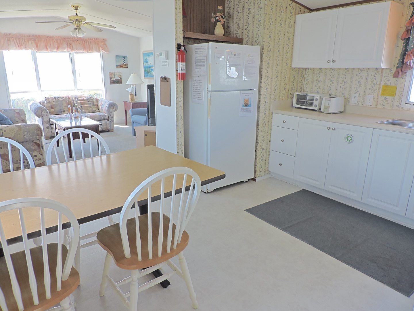 Your bright kitchen and dining area features everything needed for home cooking, with a full refrigerator, microwave, and cozy dining table.