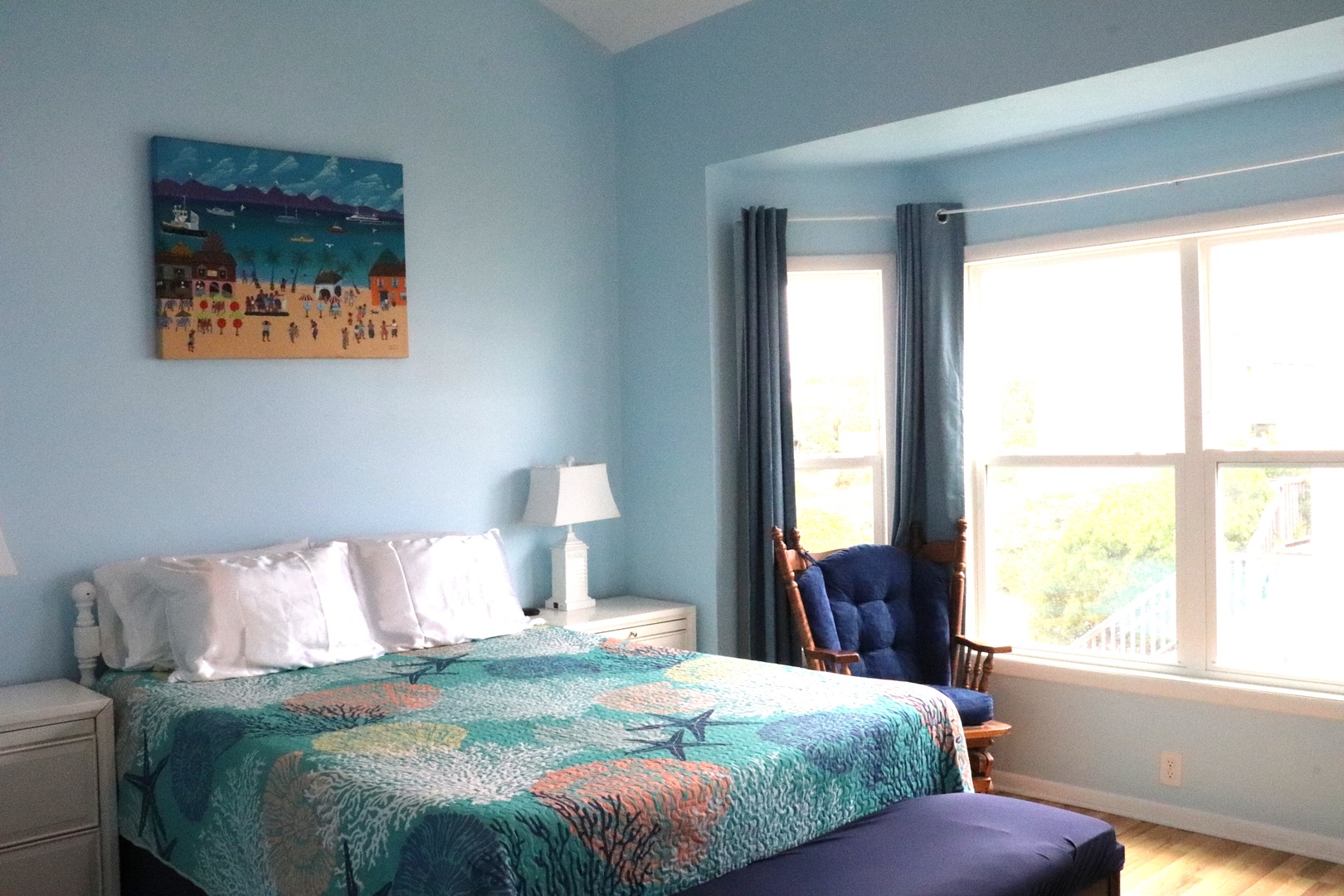 Drift off to sleep in your serene coastal-themed bedroom, where soft blue walls and ocean-inspired art create the perfect peaceful retreat after a day exploring.