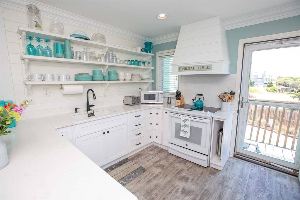 Your charming coastal kitchen features turquoise accents, open shelving, and everything you need to create memorable meals together.