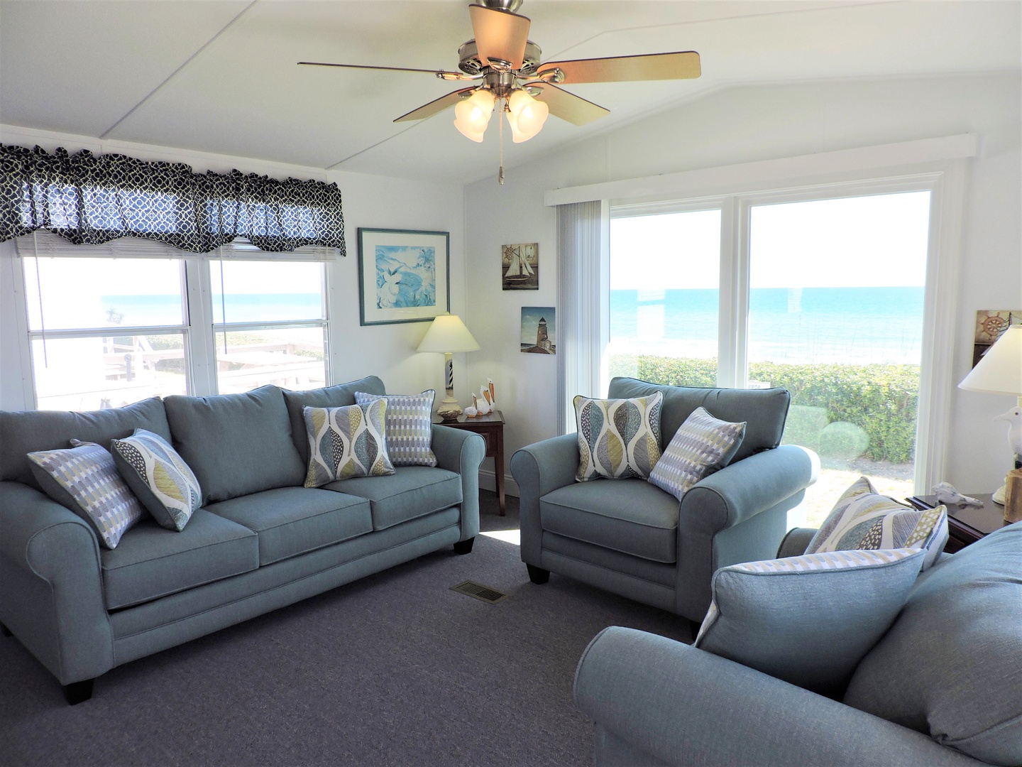 Sink into plush seating while ocean waves dance beyond your windows. This bright, coastal living room offers the perfect retreat.
