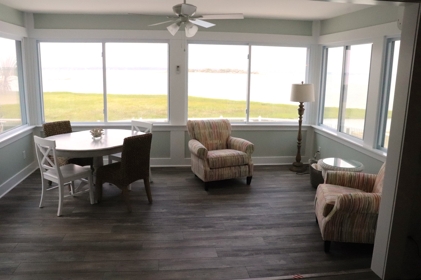 Your bright sunroom offers panoramic water views through floor-to-ceiling windows, creating a perfect spot to unwind.