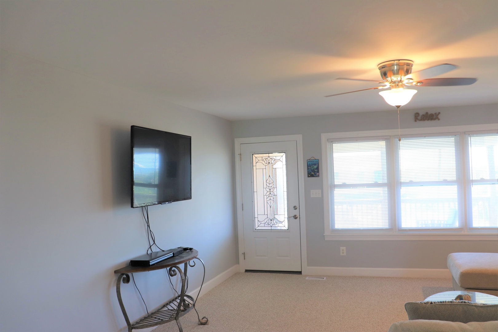 Bright, airy living space with wall-mounted TV and cozy seating awaits your arrival.