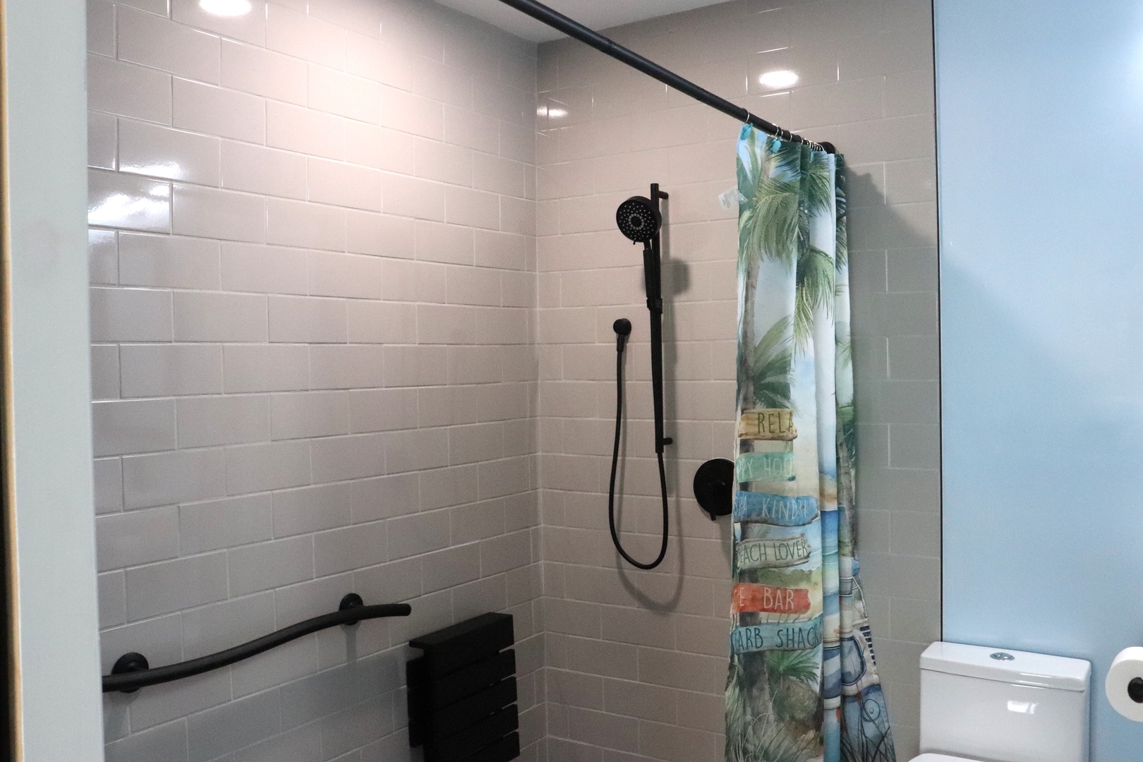 Step into your private bathroom oasis, where crisp white subway tiles and modern black fixtures create a clean, contemporary feel. The walk-in shower awaits your morning refresh.