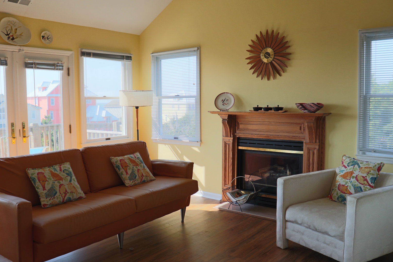 Settle into this sunny living room where warm yellow walls and cozy seating create your perfect retreat for morning coffee or evening relaxation.