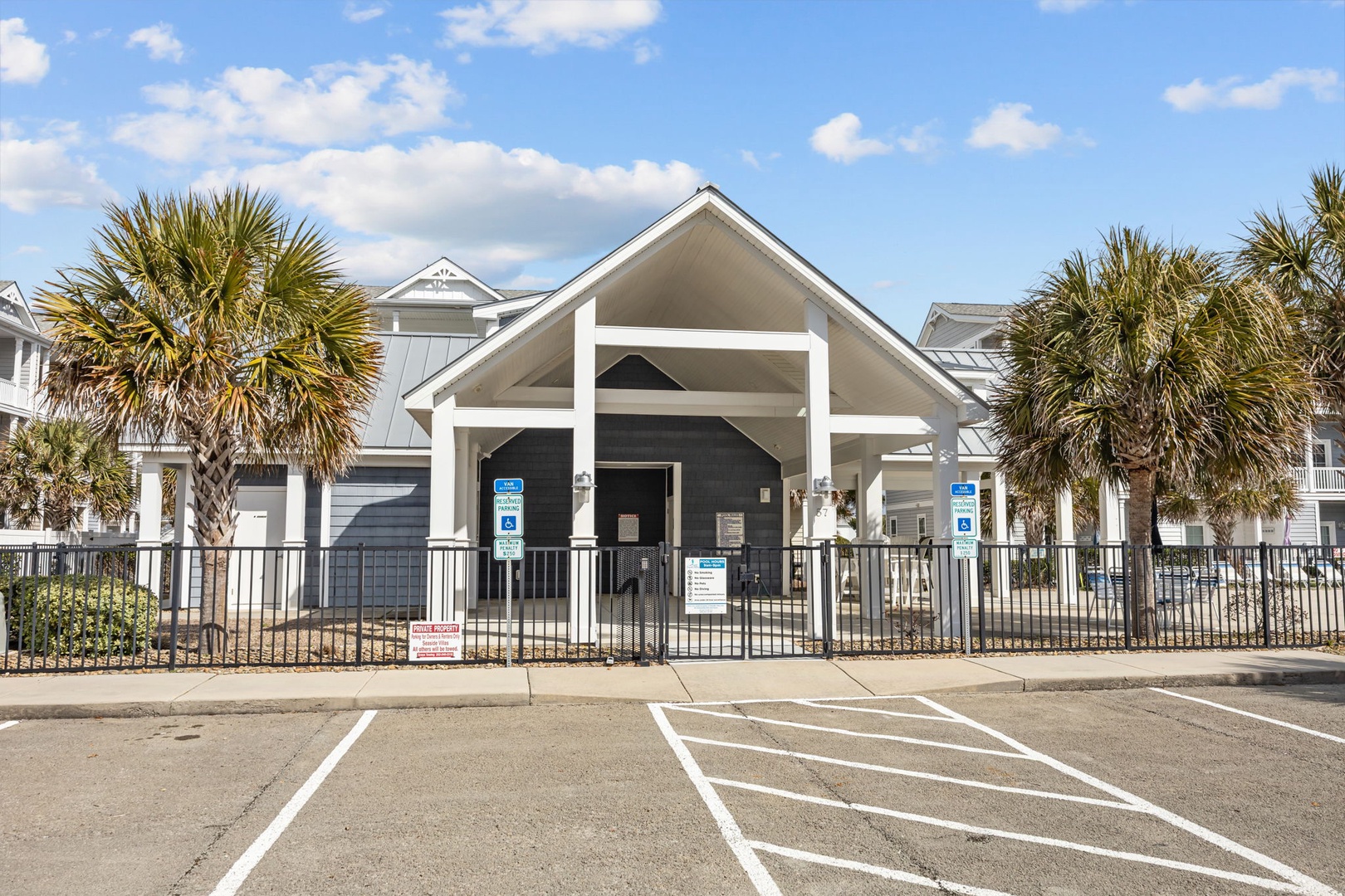 Modern beachside community center with convenient on-site parking and tropical palm landscaping.