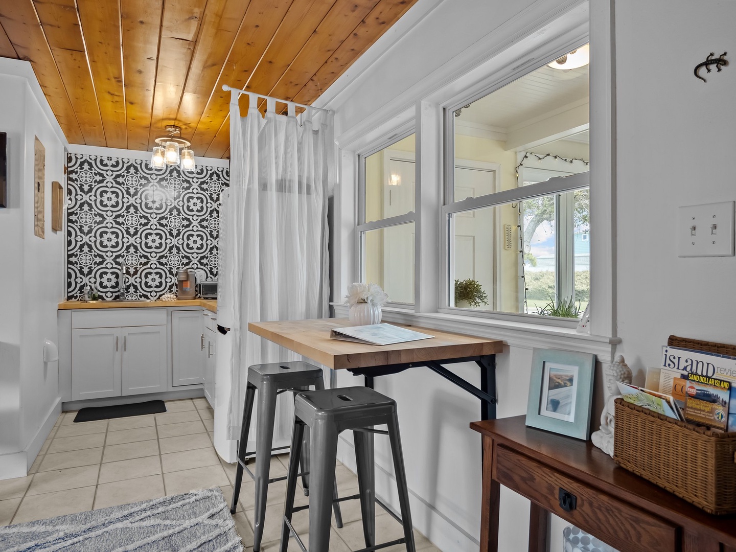 Settle into your charming breakfast nook where warm wood ceilings meet stylish tile backsplash, creating the perfect morning spot.