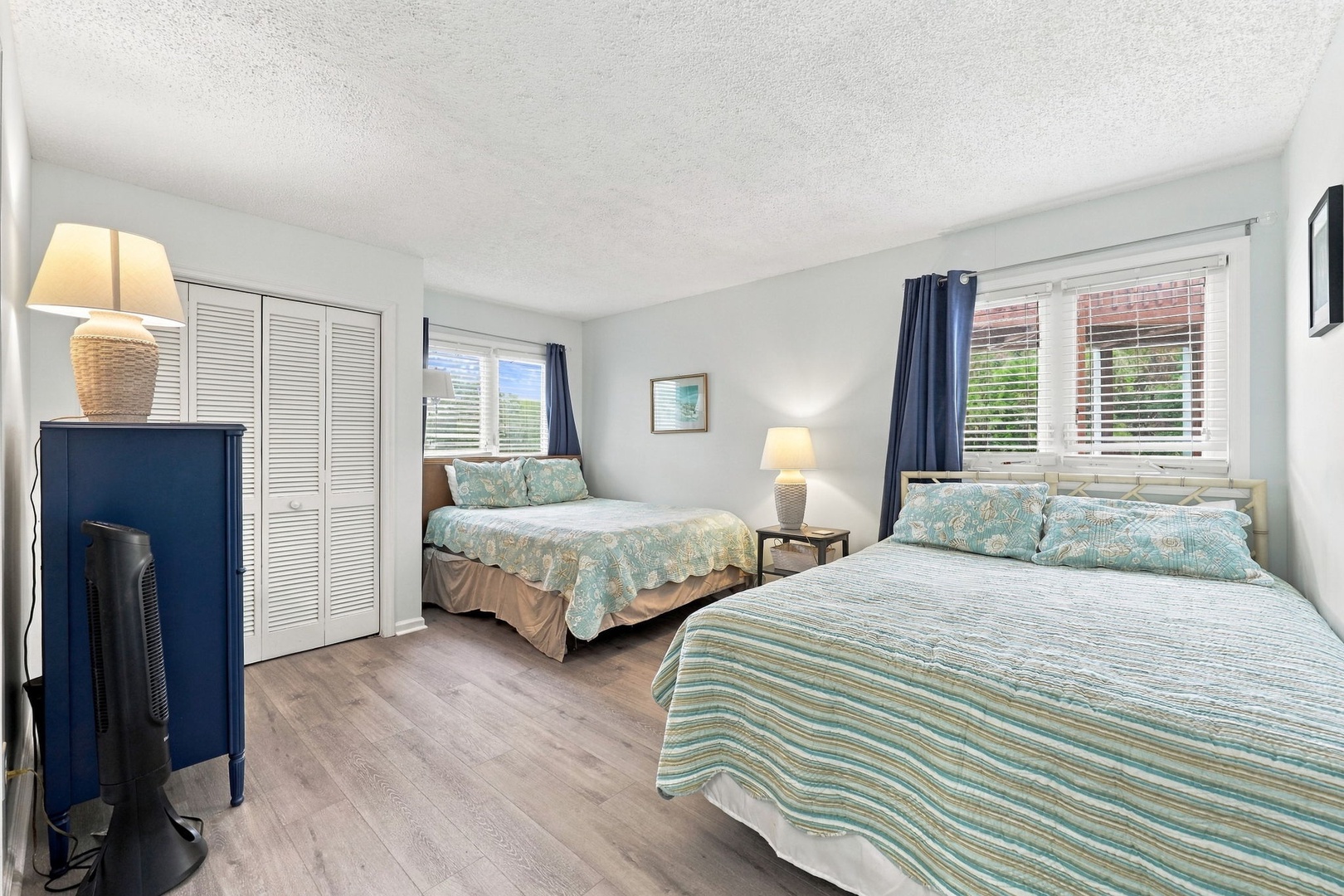 Drift off to sleep in this airy, light-filled bedroom with two comfortable beds dressed in soothing coastal tones, inviting you to unwind after a day of exploring.