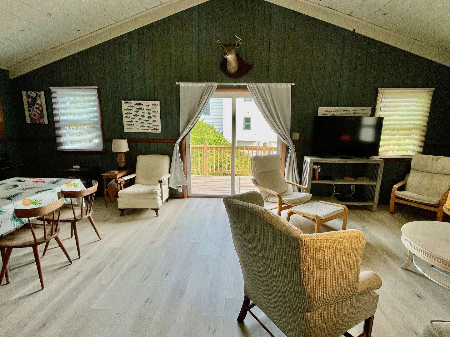 Cozy cabin living room with rustic charm where you can unwind by the TV or step out to your private balcony for fresh air.