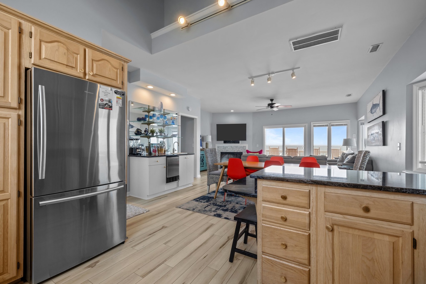 Cook meals together in this open kitchen featuring stainless steel appliances, granite countertops, and a breakfast bar overlooking the bright living area.