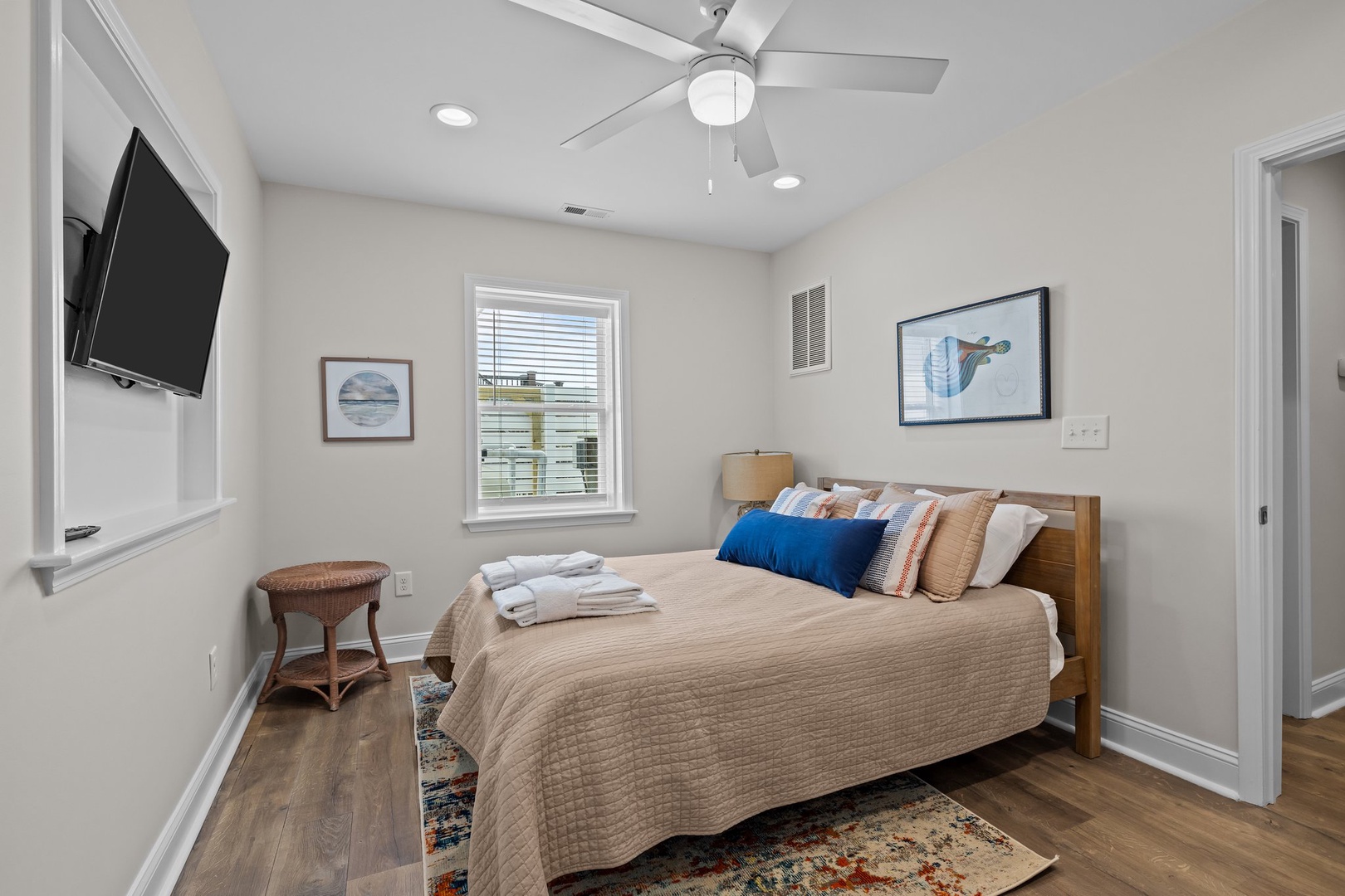 Your peaceful bedroom awaits with soft linens, gentle ceiling fan breezes, and coastal artwork creating the perfect retreat for restful nights.