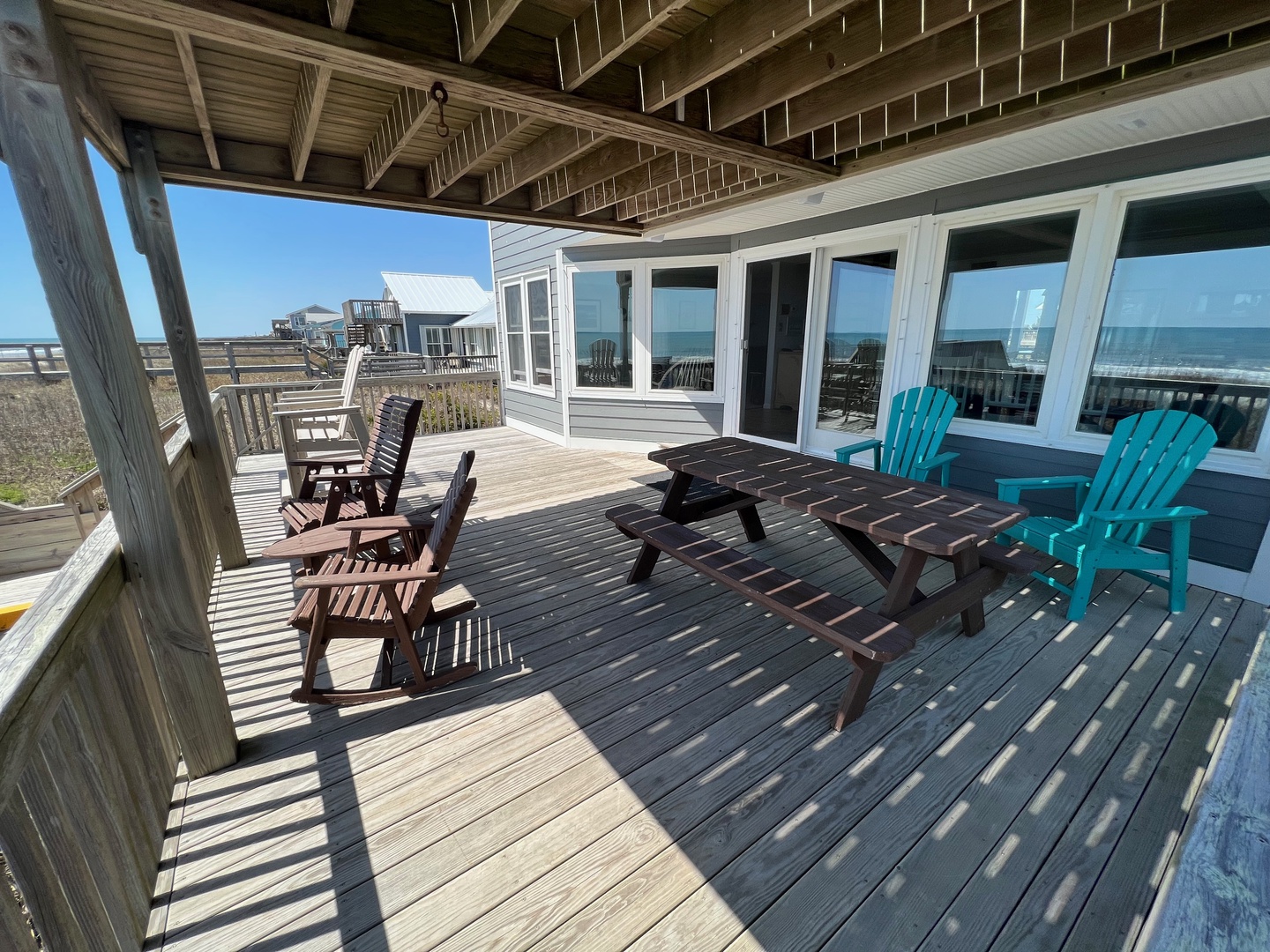 Your spacious deck offers front-row seats to ocean views, where colorful Adirondack chairs and a picnic table create the perfect spot for morning coffee.