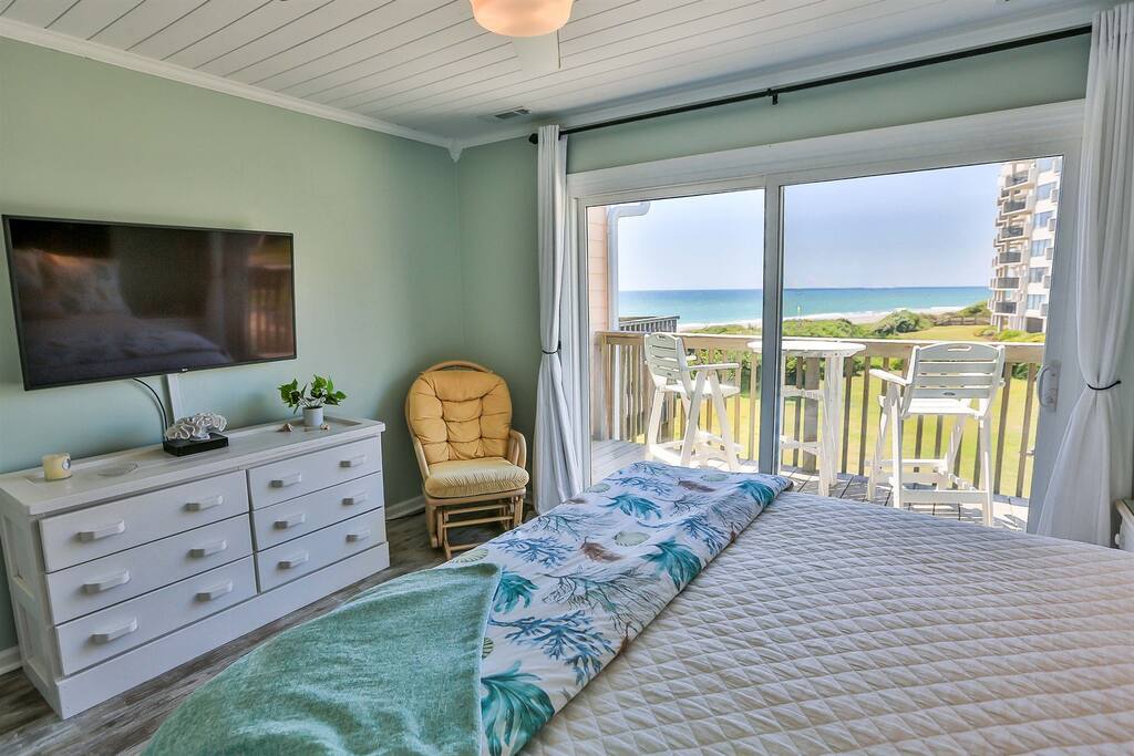 Wake up to stunning ocean views from your bed, with tropical bedding and a private balcony perfect for morning coffee overlooking the beach.