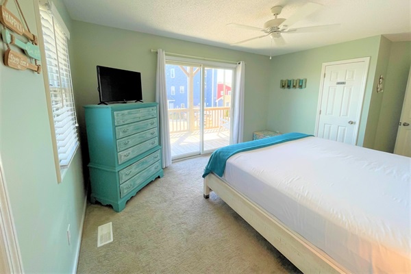 Unwind in your serene coastal bedroom with soft turquoise touches and sliding door access to your private balcony.