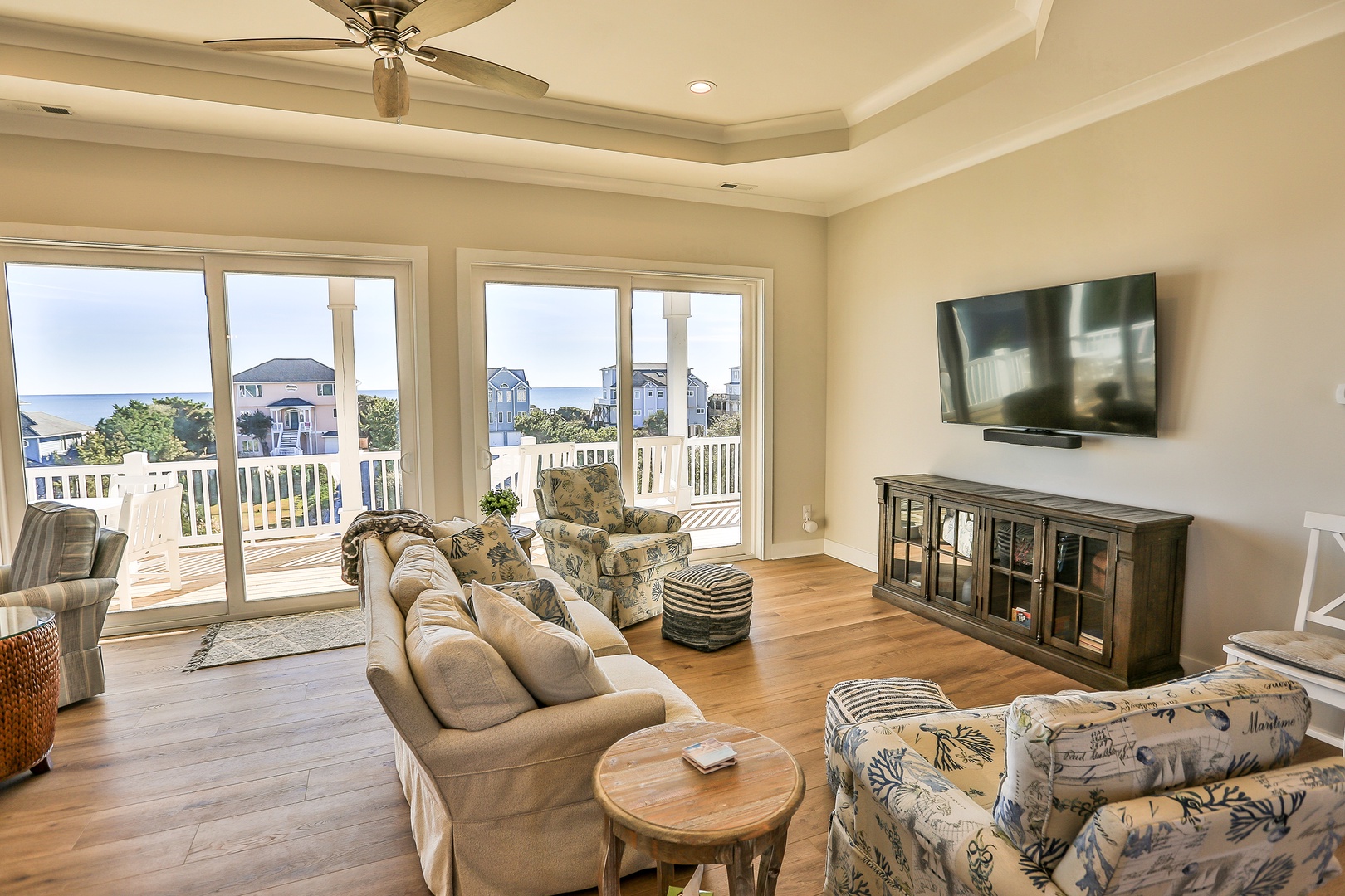 Sink into plush seating while enjoying panoramic views through floor-to-ceiling windows that frame the coastline beyond your private balcony retreat.