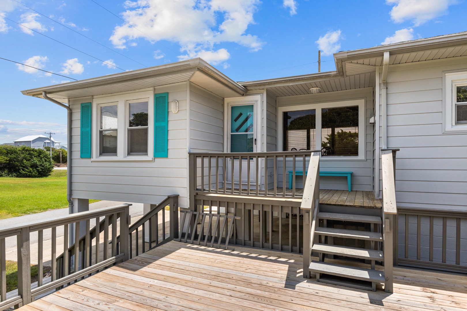 Charming beach cottage with cheerful turquoise shutters and spacious deck where you'll love morning coffee and evening sunsets.
