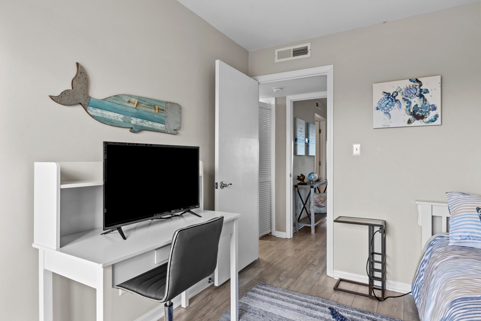 Relax in your coastal-themed room with nautical decor, modern TV setup, and workspace. A peaceful retreat with air conditioning for your comfort.