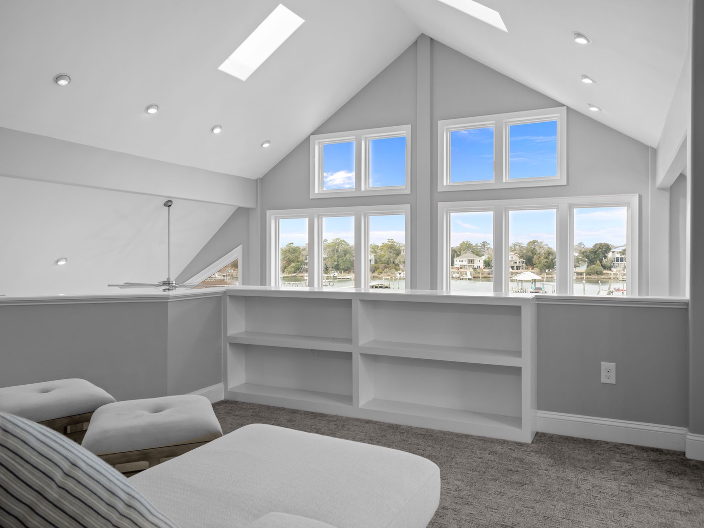 Your bright loft features soaring ceilings, built-in shelving, and stunning waterfront views through expansive windows.