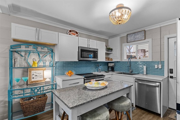 Your fully equipped kitchen awaits with granite counters, stainless appliances, and charming turquoise accents for memorable meal preparation.