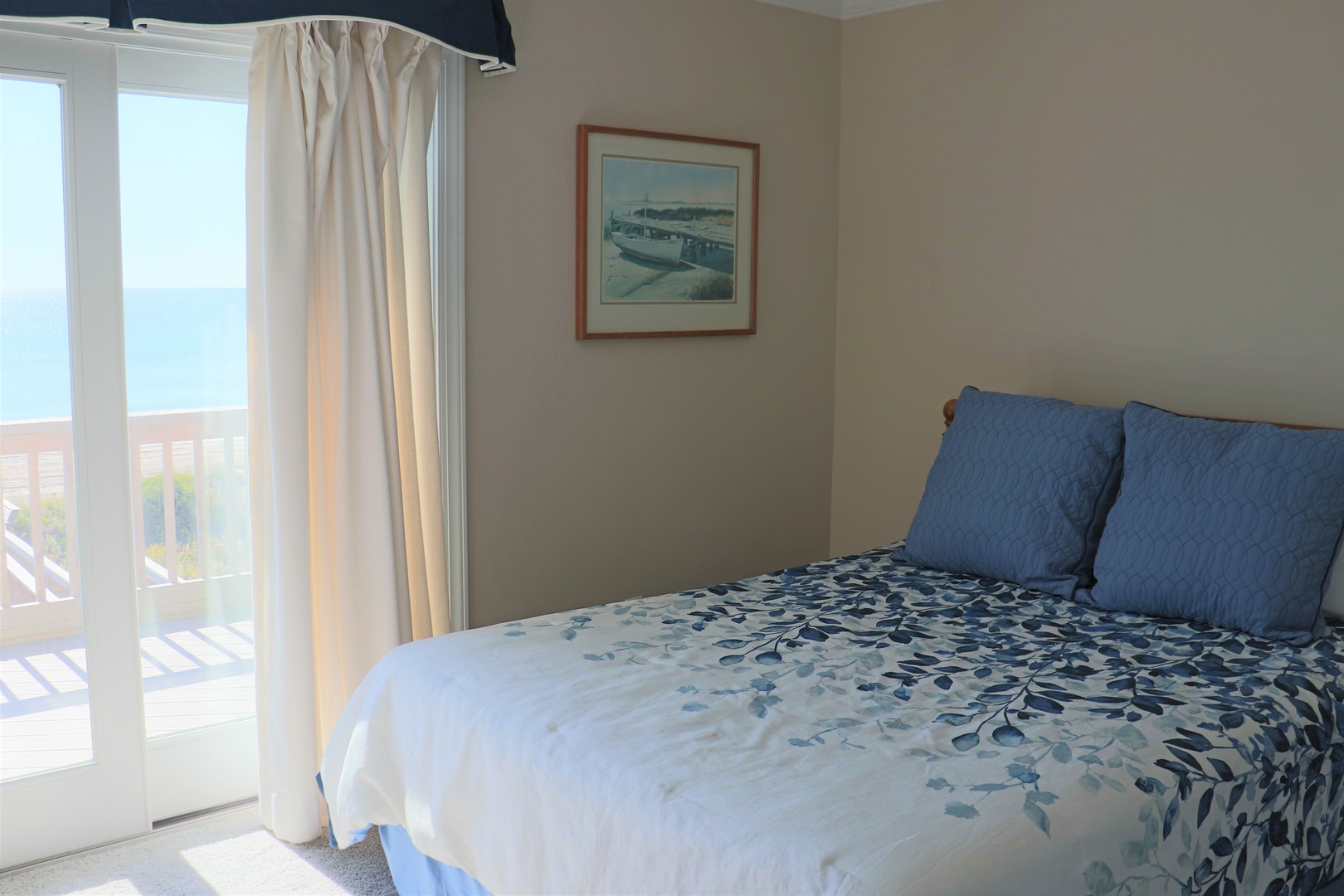 Wake up to ocean views in your peaceful bedroom, where soft blue linens and natural light create the perfect coastal retreat.