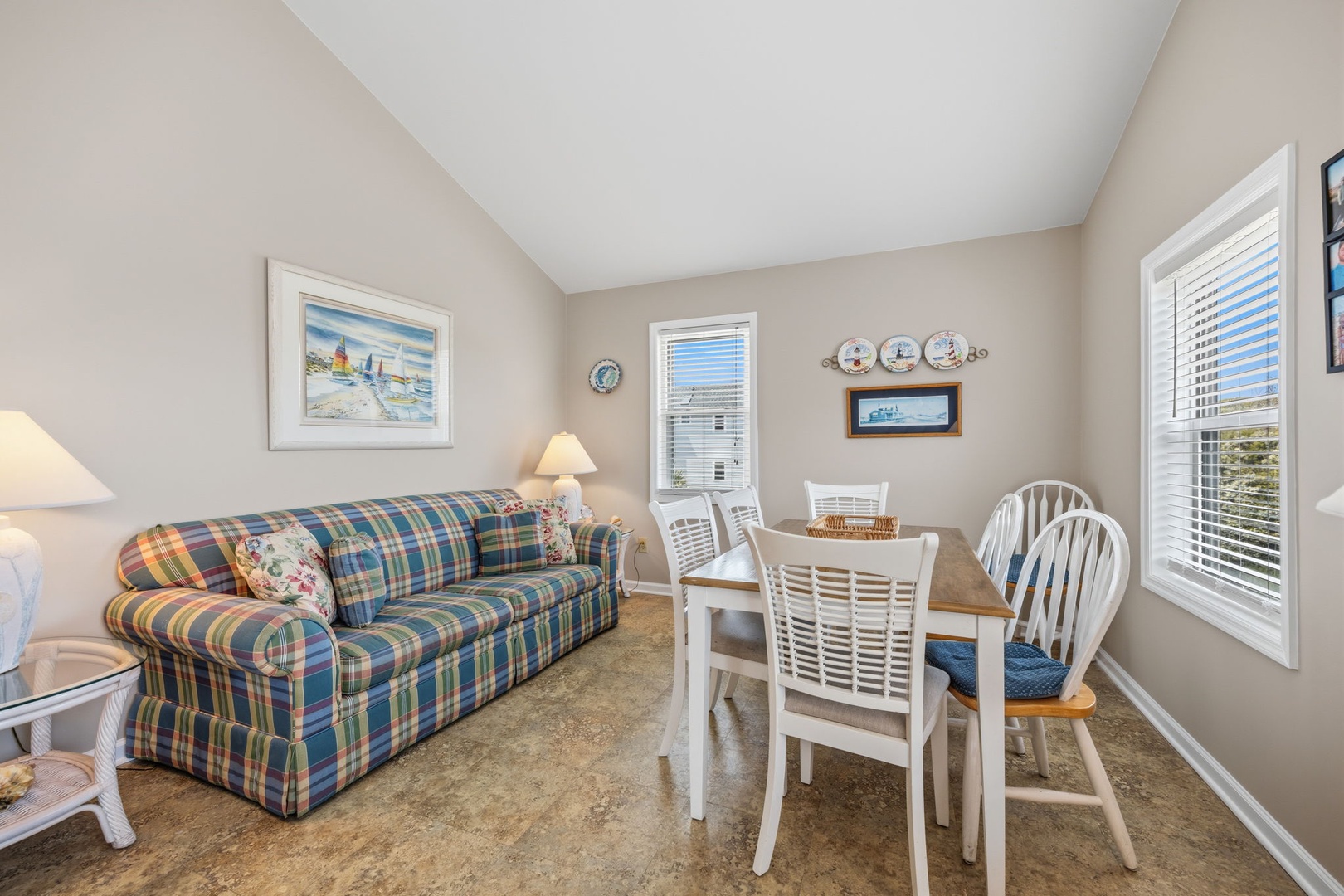 Your cozy living space features a comfortable plaid sofa and dining table, perfect for family meals and evening relaxation.